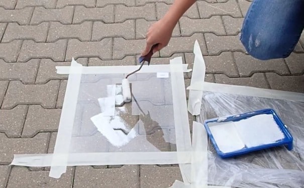 Malowanie znaku z szablonu na kostce brukowej